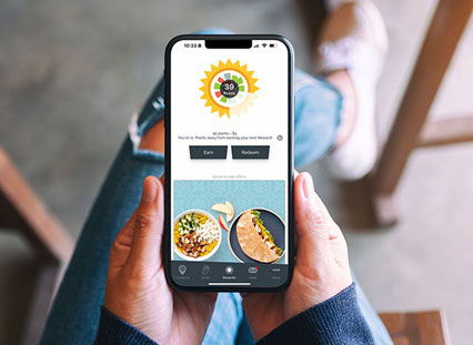 woman holding iphone with the Garbanzo rewards app open
